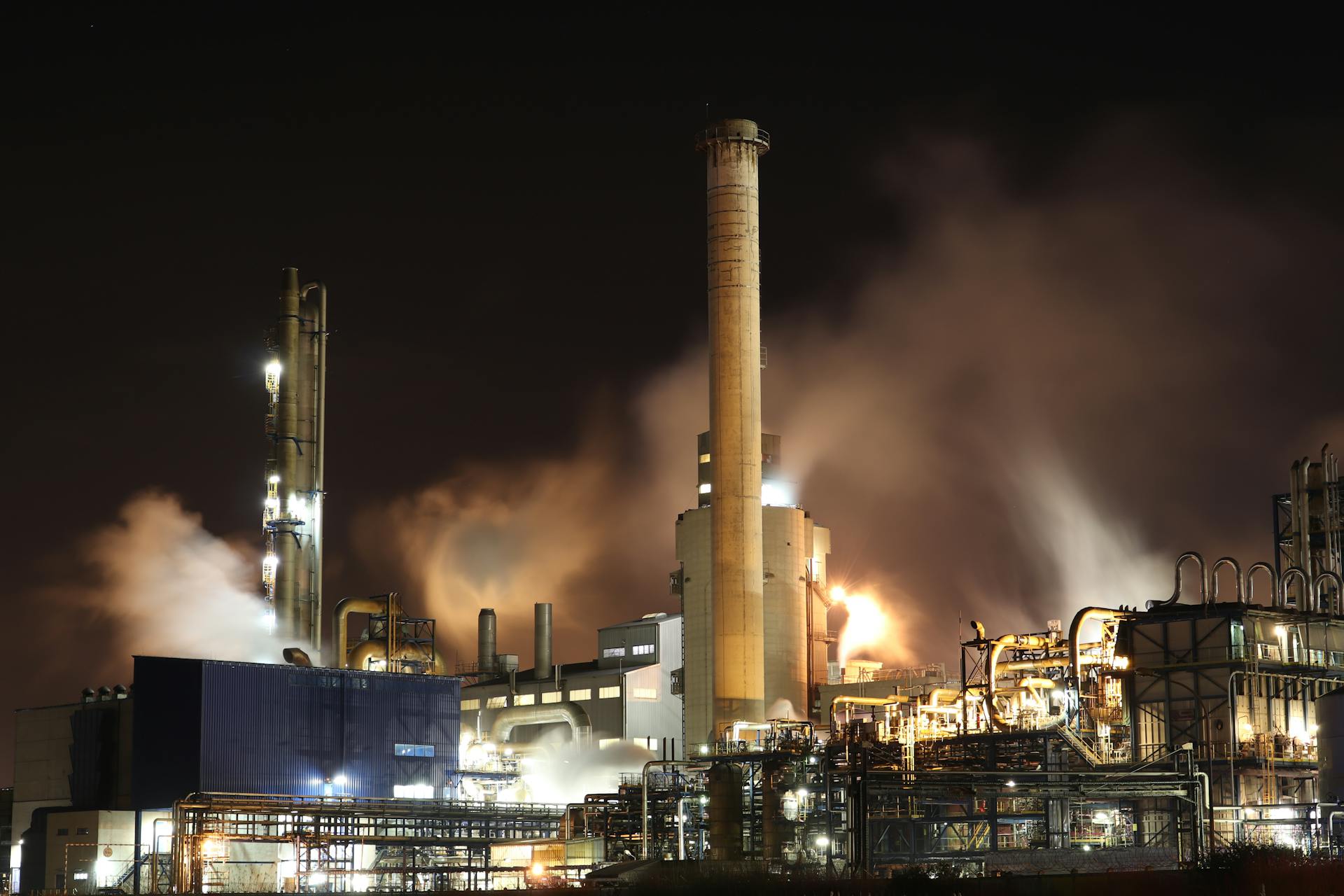 pexels-loic-manegarium-3855962 Industrial gas processing plant at night with smoke and steam emissions – ensuring safe and reliable propane and natural gas odorization.